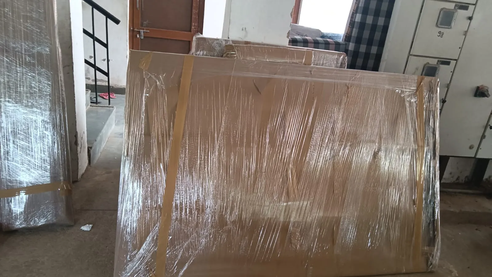 Large flat item packed in cardboard and plastic sheeting, ready to move