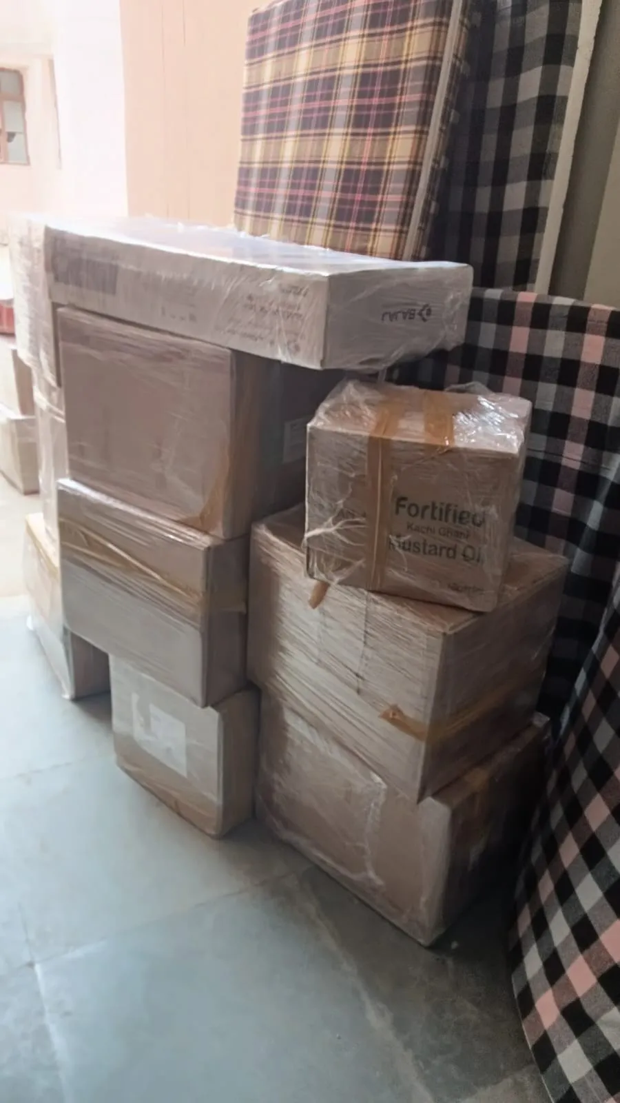 Packed cartons stacked beside a mattress during a household move