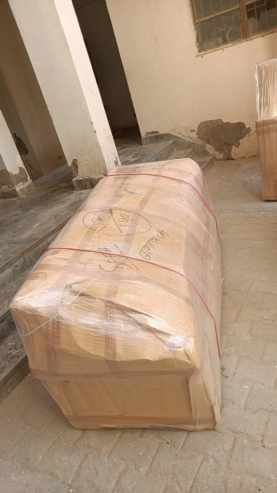 Sofa packed in a wooden crate, wrapped in plastic and secured with straps