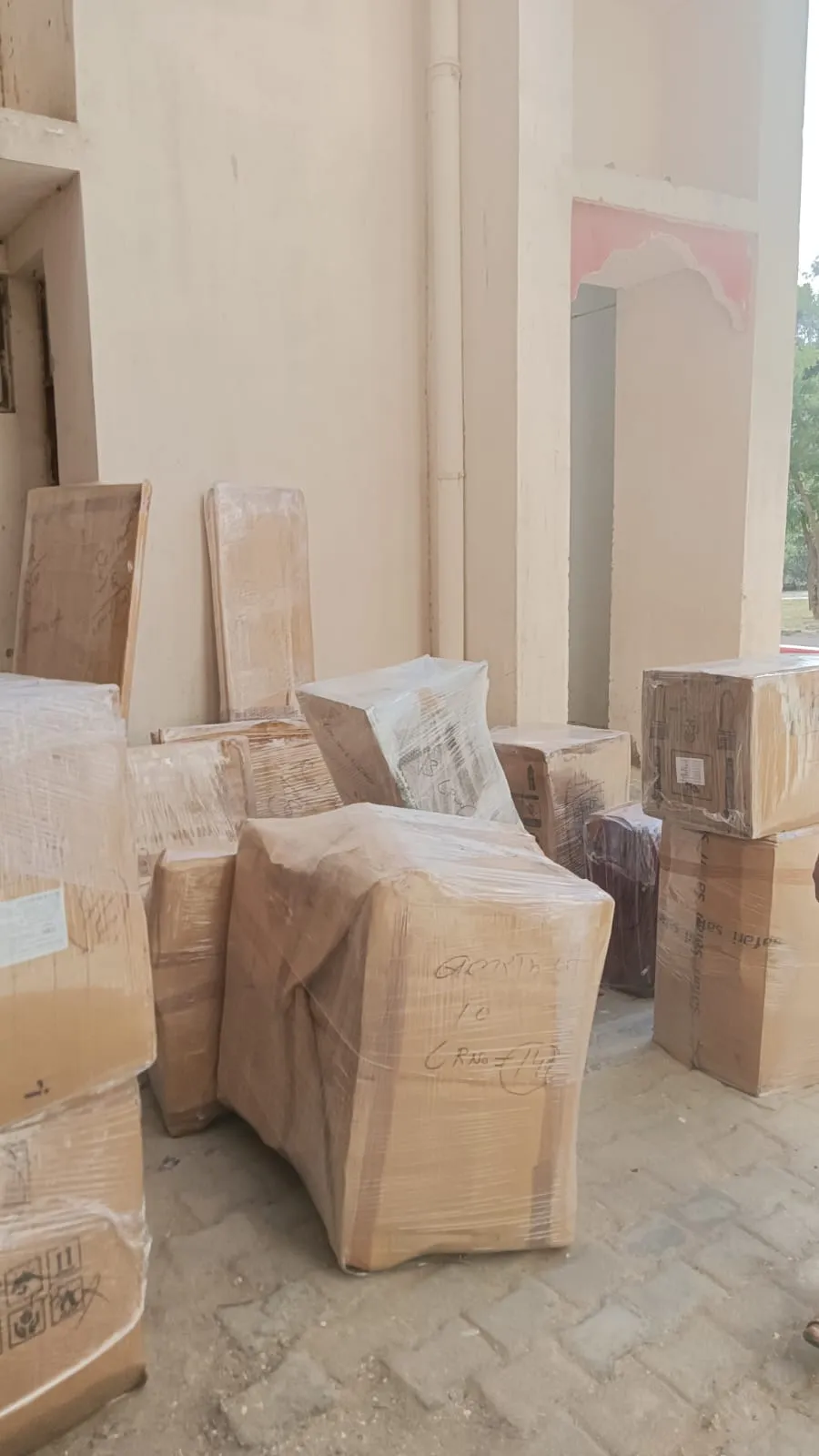 Plastic-wrapped boxes and panels staged on a walkway before loading