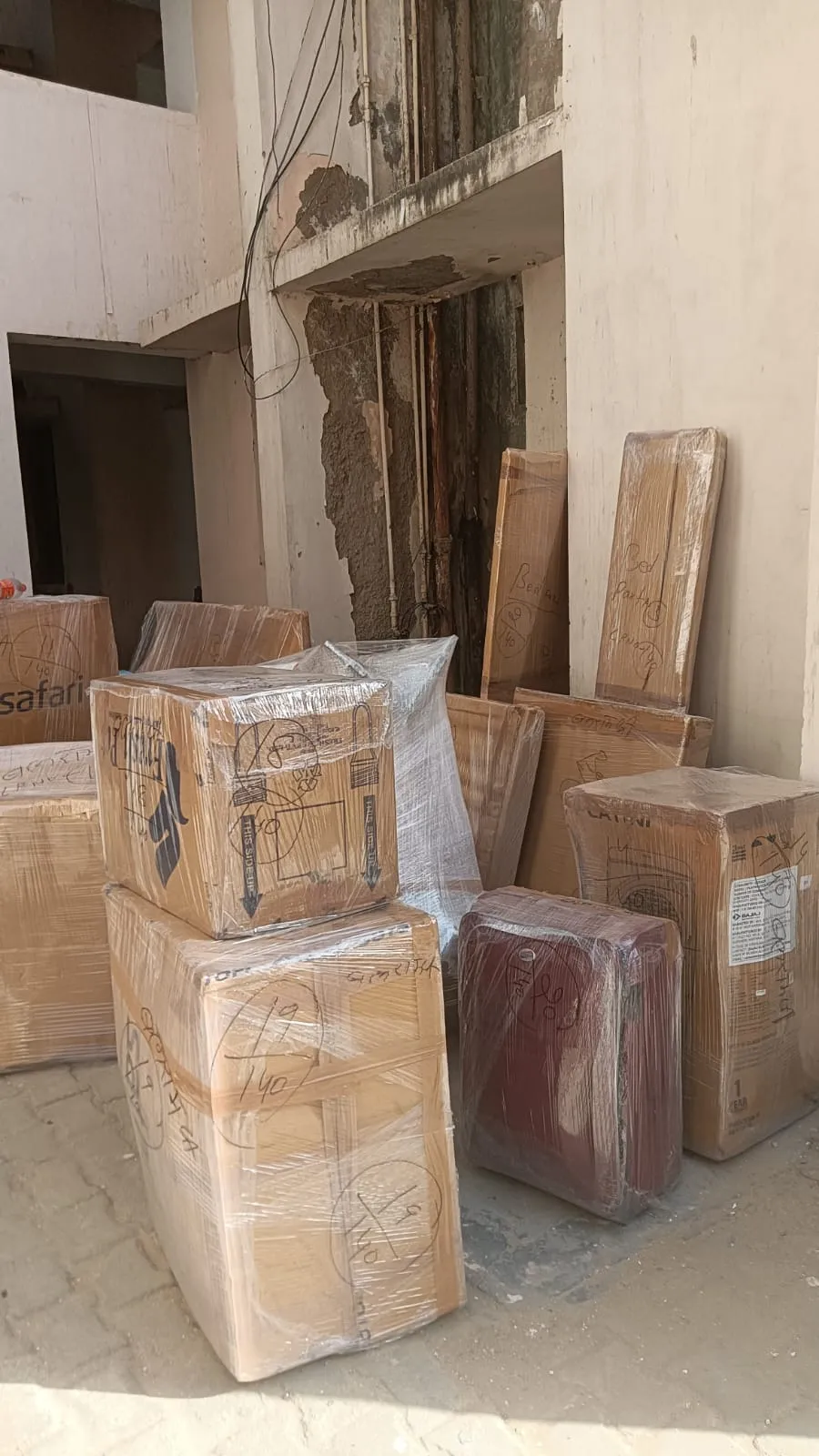 Packed cartons, a suitcase and wooden boards stacked for a house shifting job